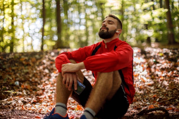 person meditating outdoors, using smartwatch