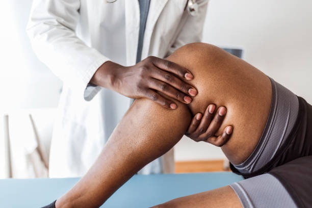 sports doctor examining athlete, discussing rehabilitation plan