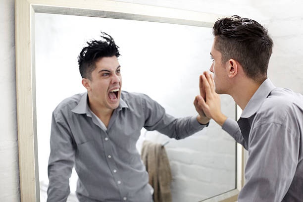 person looking in mirror, sad expression