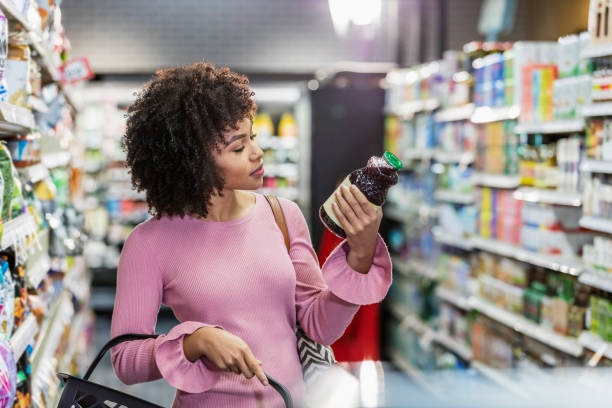person looking at food labels in supermarket