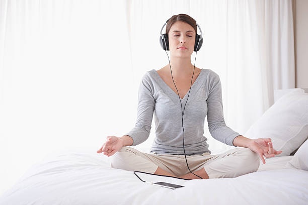 person meditating with headphones on