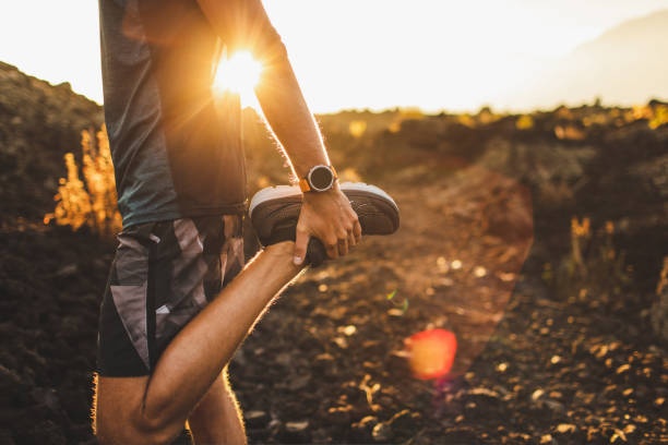 person wearing fitness tracker running outdoors, sunny day