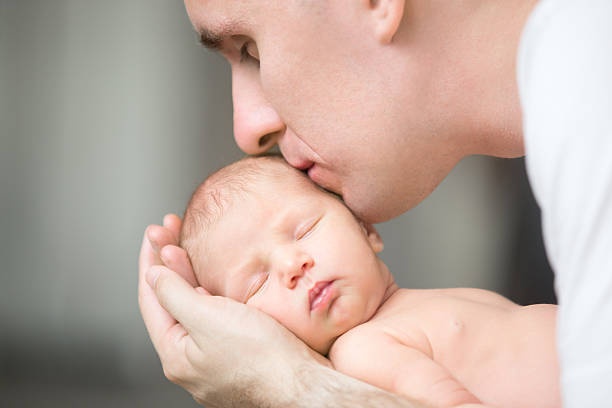 parent holding newborn baby gently