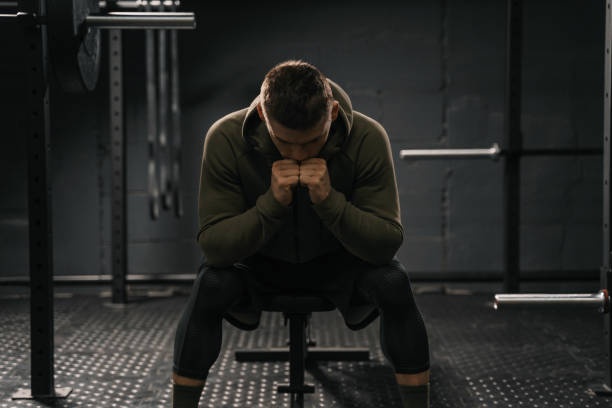 person looking stressed, gym, weights, unhealthy obsession