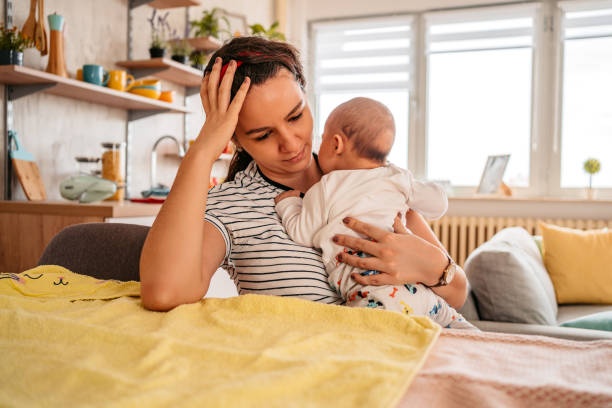 tired mother holding baby, overwhelmed look