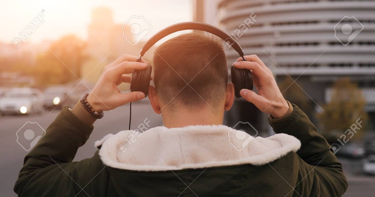 person listening headphones,music,city background