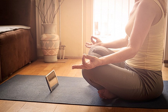 person meditating with a mindfulness app on their phone