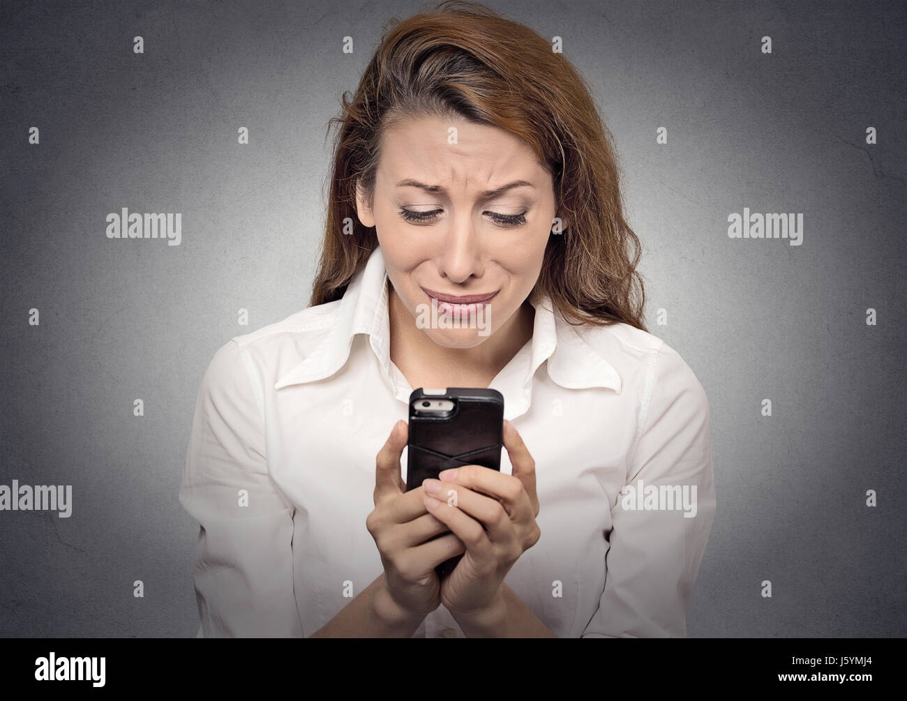 person looking at smartphone with stressed expression