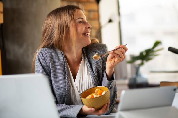 woman eating healthy snack at desk