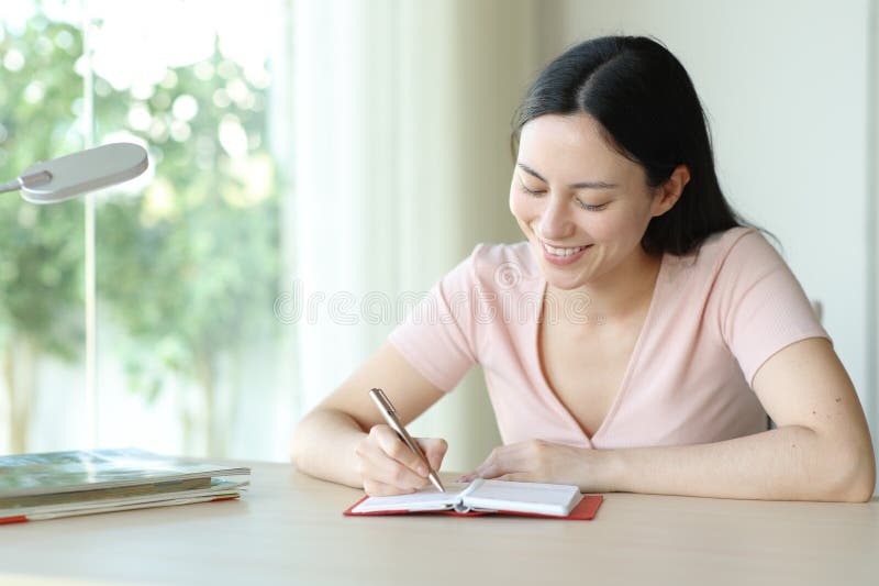 person smiling confidently, writing in a notebook