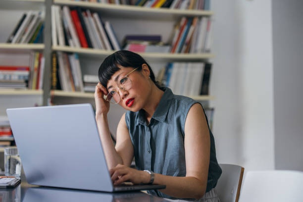 Woman working on laptop, stressed, deadline