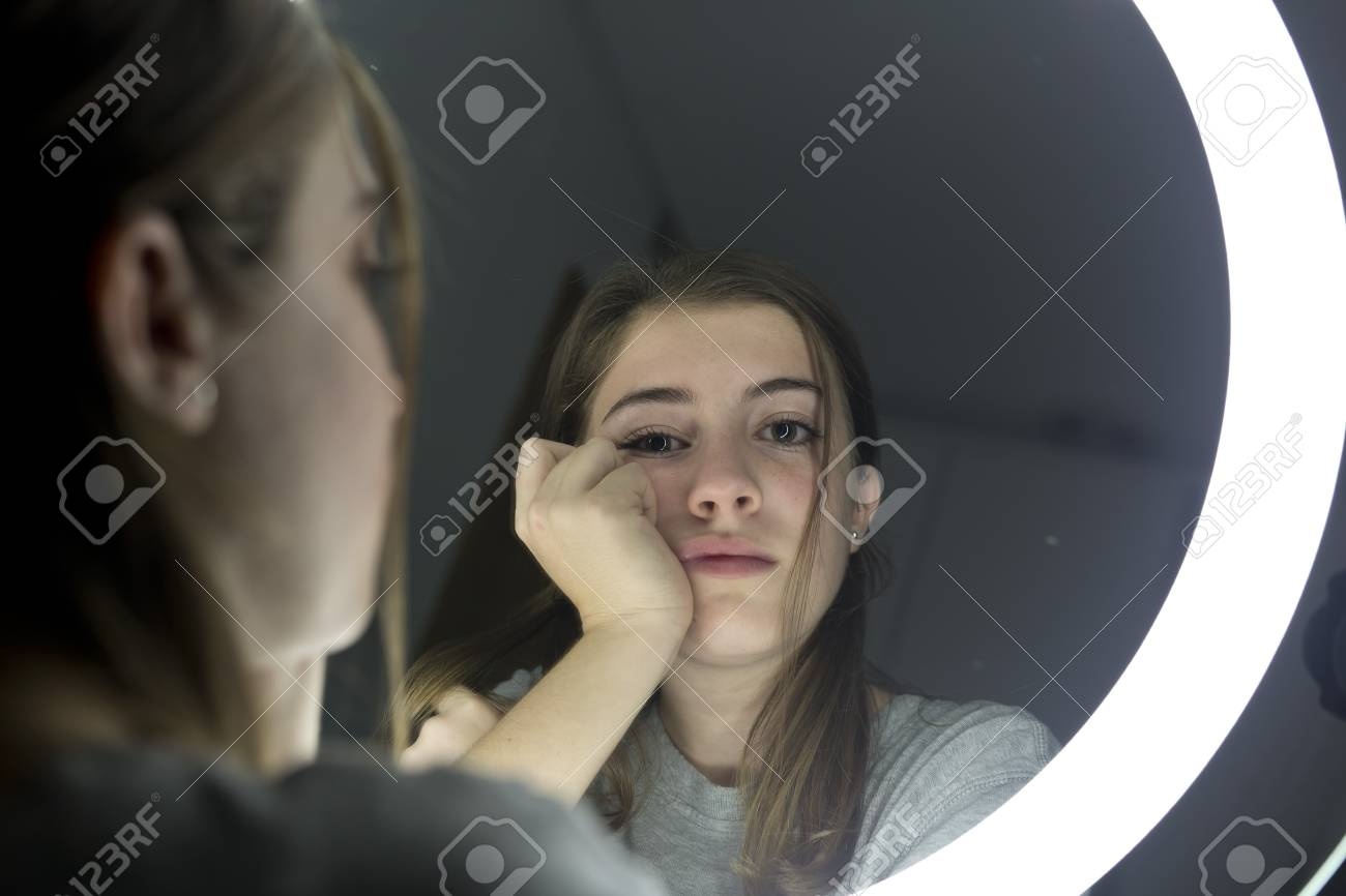 person looking in mirror, sad expression