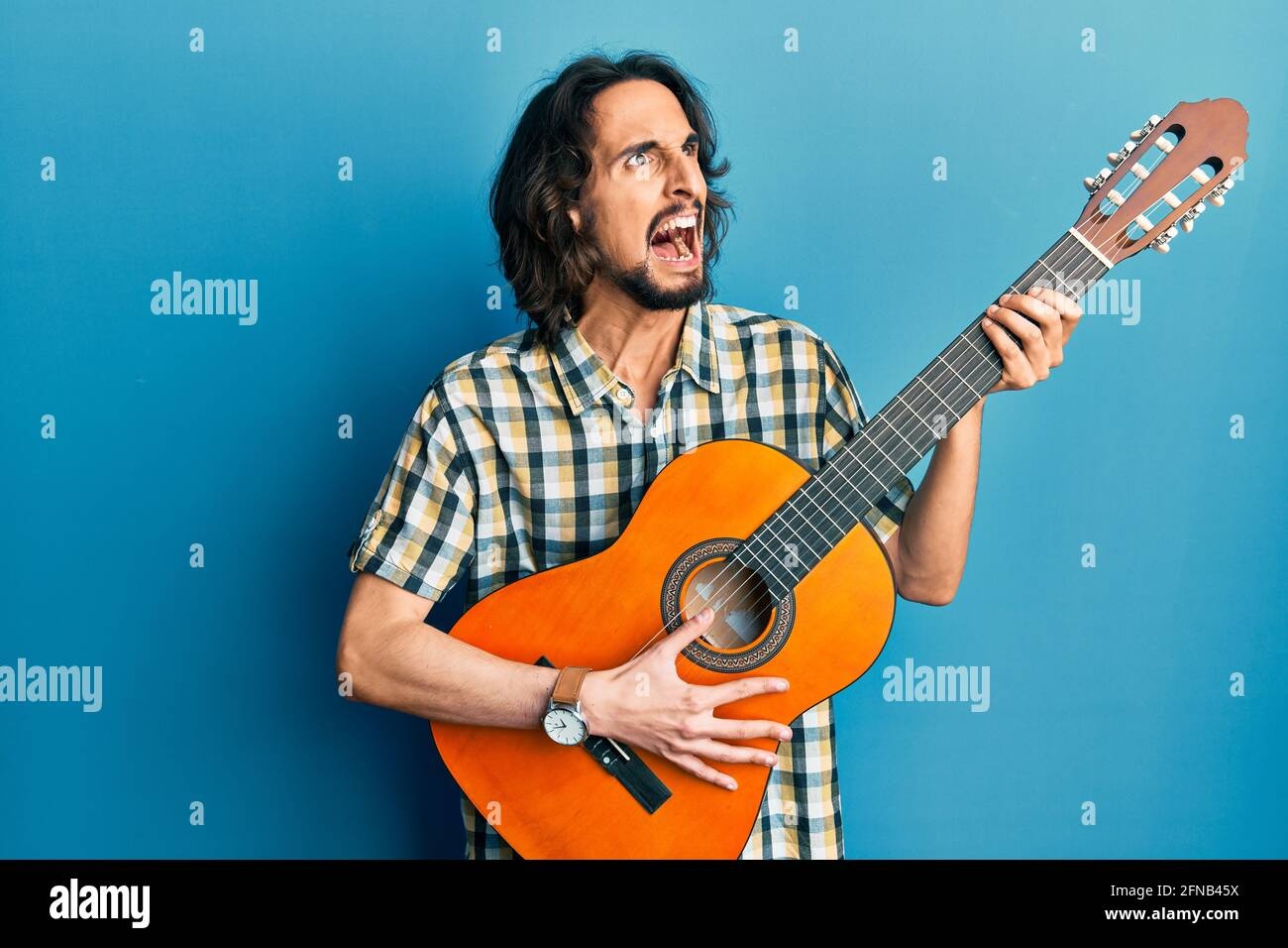 musician playing guitar intensely, frustrated expression