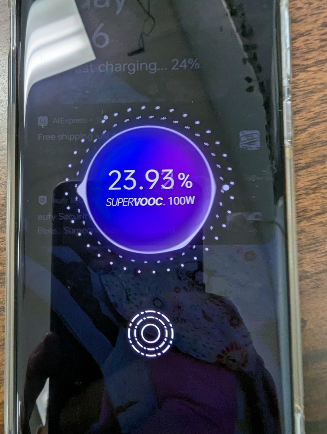 OnePlus 12, blue, lying on table, displaying fast charging animation