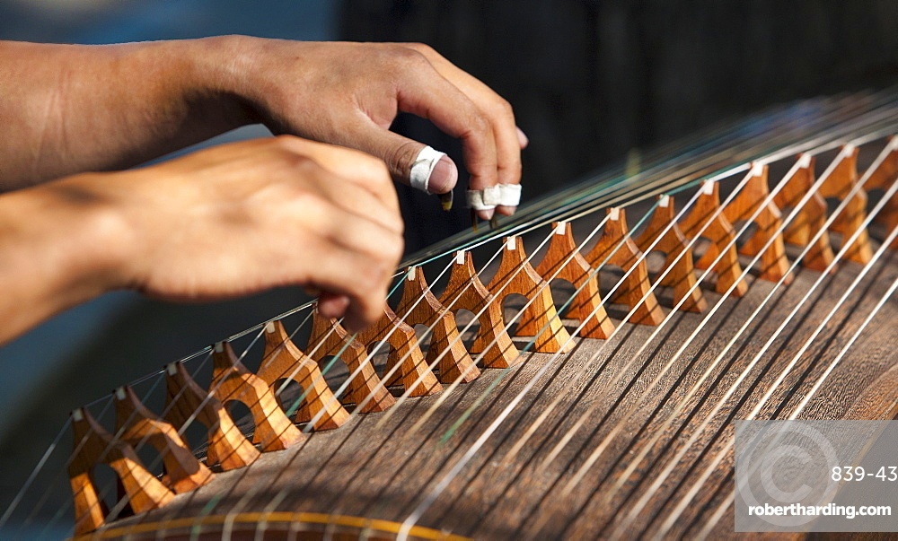 Close-up of hands playing a traditional folk instrument
