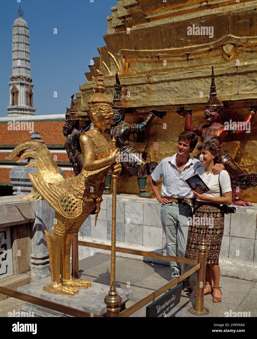 thai_temple,golden_statue,tourist_taking_photo