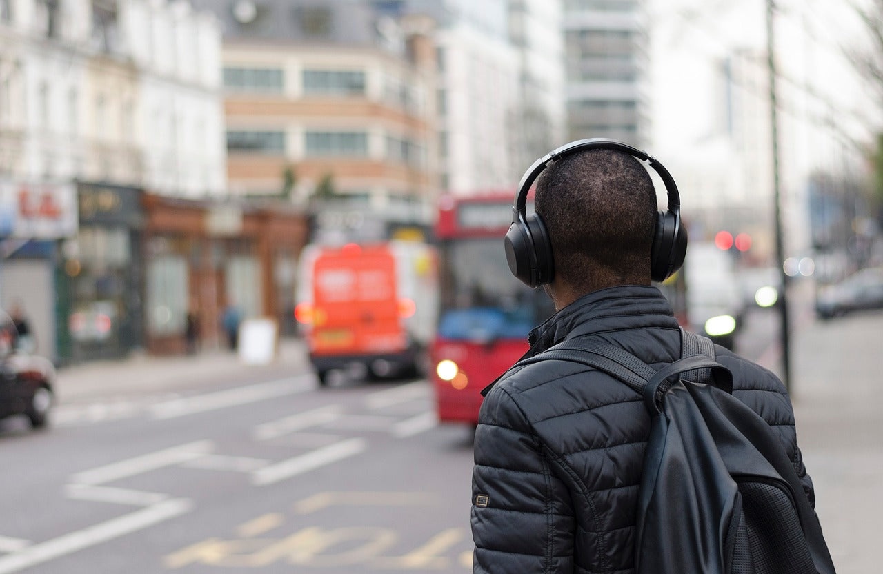 noise cancelling headphones, urban scene, busy street