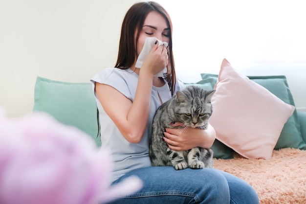 sad woman hugging cat, allergies, sneezing